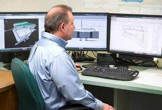 Man at desk with three monitors